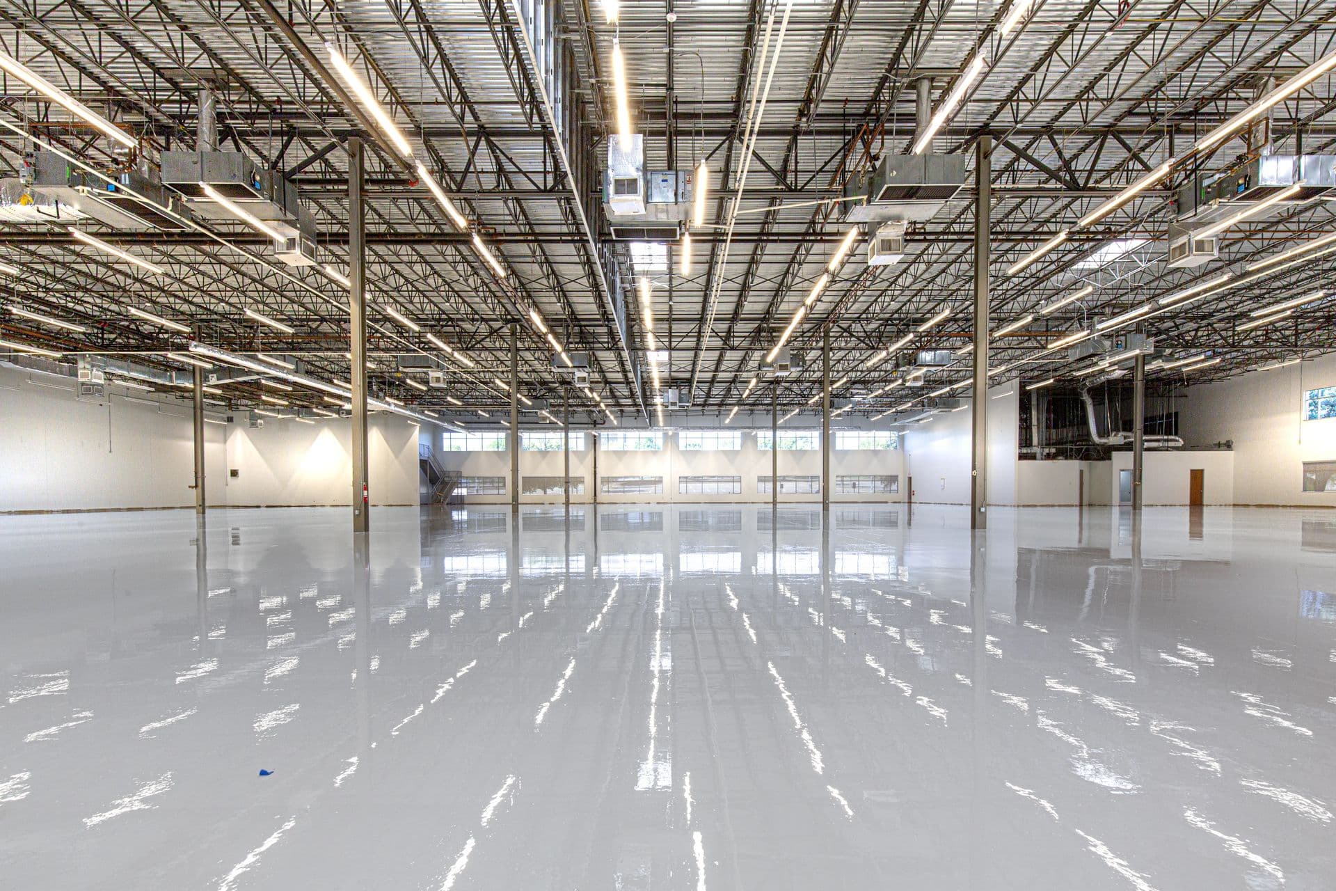 Flawless seamless high-gloss epoxy floor spanning a large industrial space